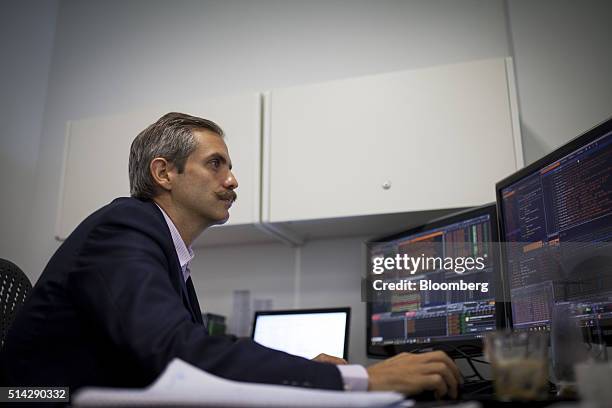 Carmelo Haddad, managing director of Knossos Asset Management, views a computer screen during an interview in the company's offices in Caracas,...
