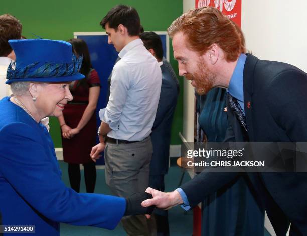 Britain's Queen Elizabeth II shakes hands with British actor Damien Lewis during a visit to the Prince's Trust Centre in Kennington in London on...