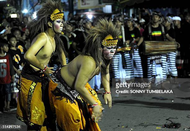 Balinese dancers perform a routine as an effigy called "Ogoh-ogoh" which symbolises evil is carried during a parade in Tuban near Denpasar on...