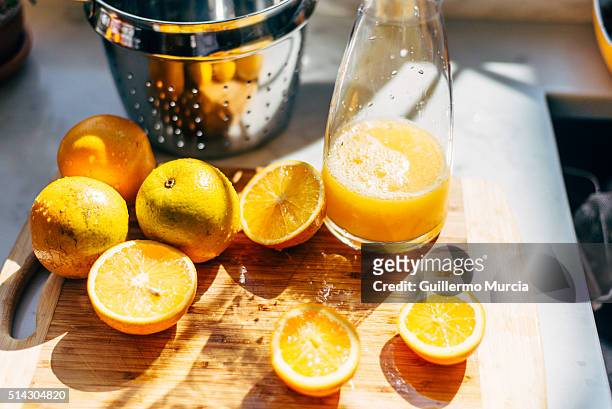 oranges for juice on a cutting board - orange juice stock-fotos und bilder
