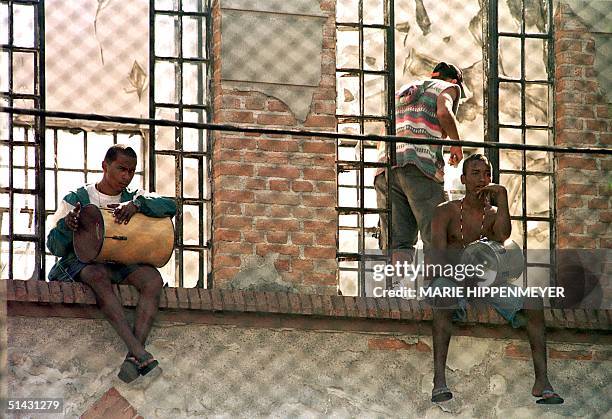 Two inmates at the juvenile detention center known as "Febem" beat on drums at the windows of one of the jail's pavilions 05 May 1999 during the...