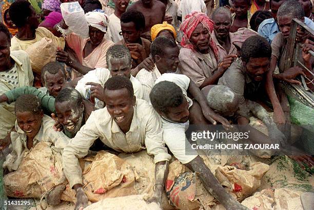 Somalis fight over corn flour during a food distribution in Mogadishu, Somalia, 11 October 1993. Some 2,000 supporters of Mohamed Farah Aidid...