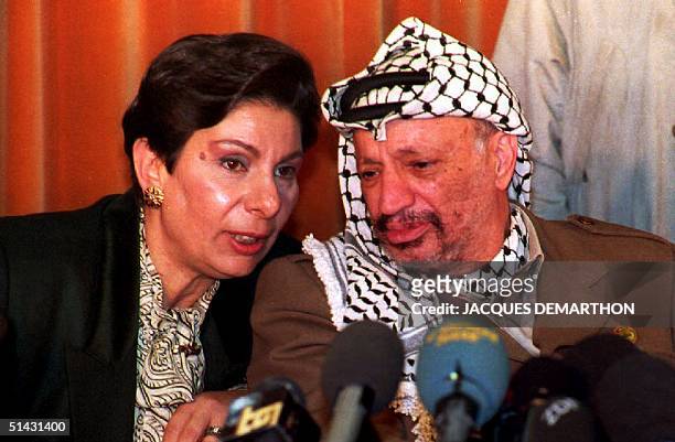Leader Yasser Arafat speaks with Hanan Ashrawi, spokeswoman of the Palestinian delegation to the Middle East peace talks, during a press conference...