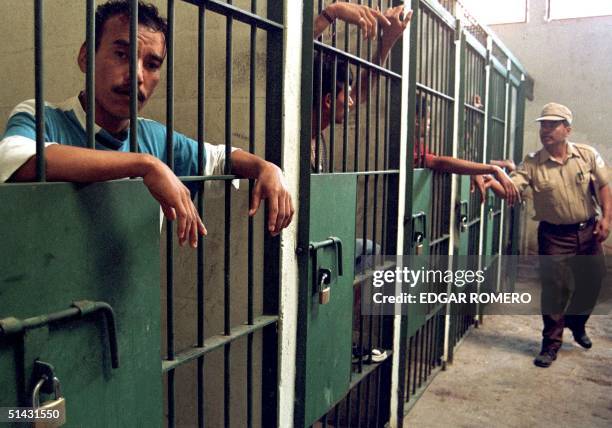 An Apanteos prison guard in Santa Ana, 60kms west of San Salvador, checks the names of inmates 01 February after an armed attack on the prison early...