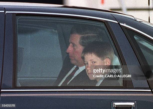 Prince Harry looks at photographers as he and father, Prince Charles, drive away from the Vancouver International Airport after they arrived to start...