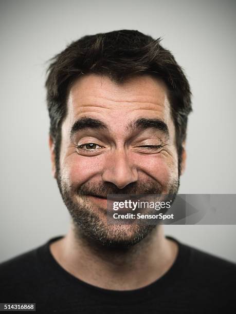 retrato de un hombre joven caucásica real - winking fotografías e imágenes de stock