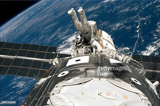 This image released 13 December by NASA shows US space shuttle Endeavour crew member Jim Newman of the US wraps up work 12 December on the outside of...