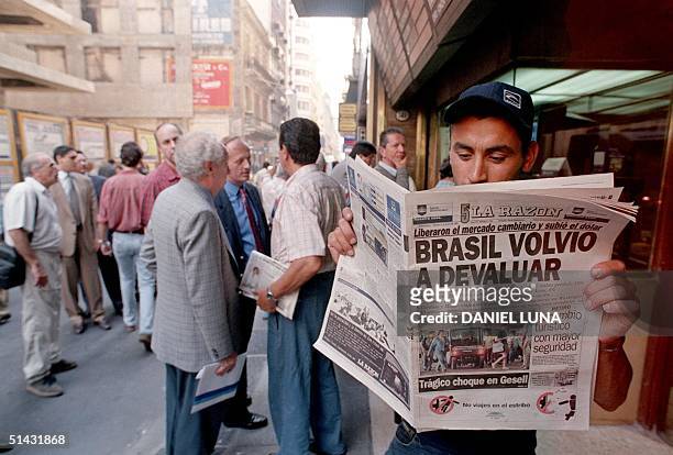 An unidentified man reads a local newspaper discussing the Brazillian government's new devaluation 15 January, in the center of Buenos Aires, Brazil....