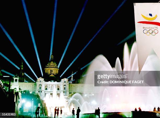 Light beams cross the sky over the "Font Magica" fountain and the Palau Nacional late 16 July 1992, as the city gives the last touch to its main...