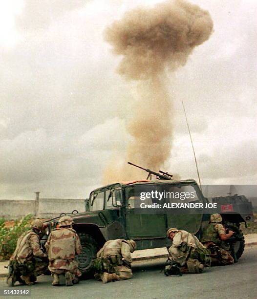 Marines take cover 12 June 1993 during an explosion set by U.N. Forces at an arms depot belonging to the forces of Somali warlord Gen. Mohamed Farrah...