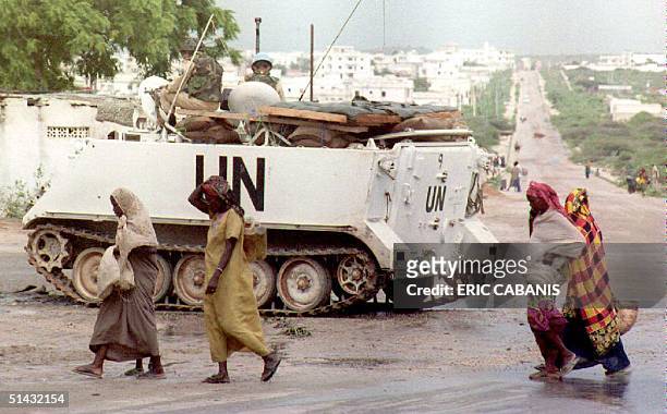 Somali women pass a U.N. Armored vehicle 25 June 1993. Since 05 June, when battles between U.N. Troops and loyalists of Somali warlord Mohamed Farrah...