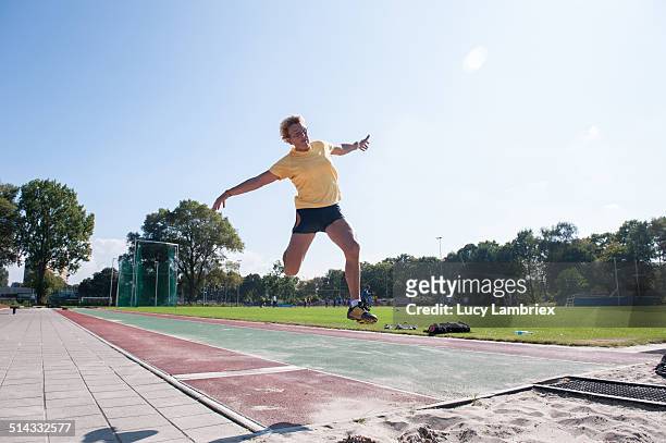 senior athlete (75) practicing long jump - mens long jump stockfoto's en -beelden