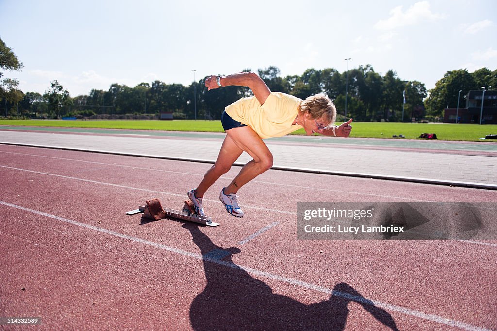 Female senior athlete (75) taking off for a sprint