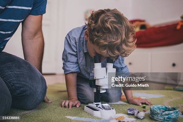 little boy using microscope. - neugierde stock-fotos und bilder