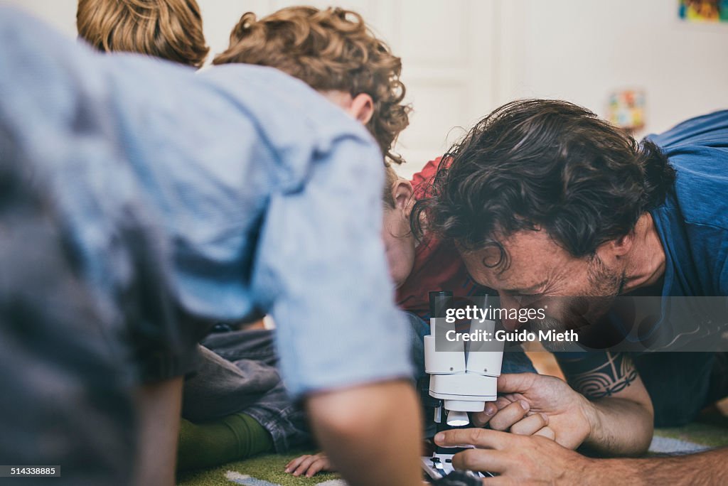 Family playing with microscope.