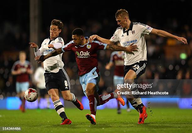 Andre Gray of Burnley is tackled by Scott Parker and Dan Burn of Fulham during the Sky Bet Championship match between Fulham and Burnley at Craven...