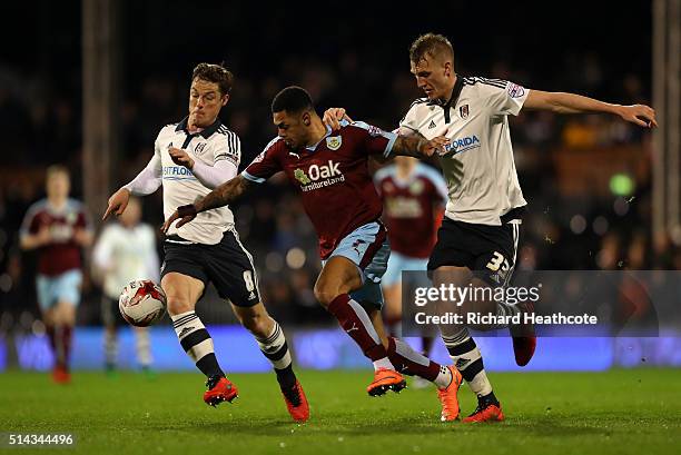 Andre Gray of Burnley is tackled by Scott Parker and Dan Burn of Fulham during the Sky Bet Championship match between Fulham and Burnley at Craven...