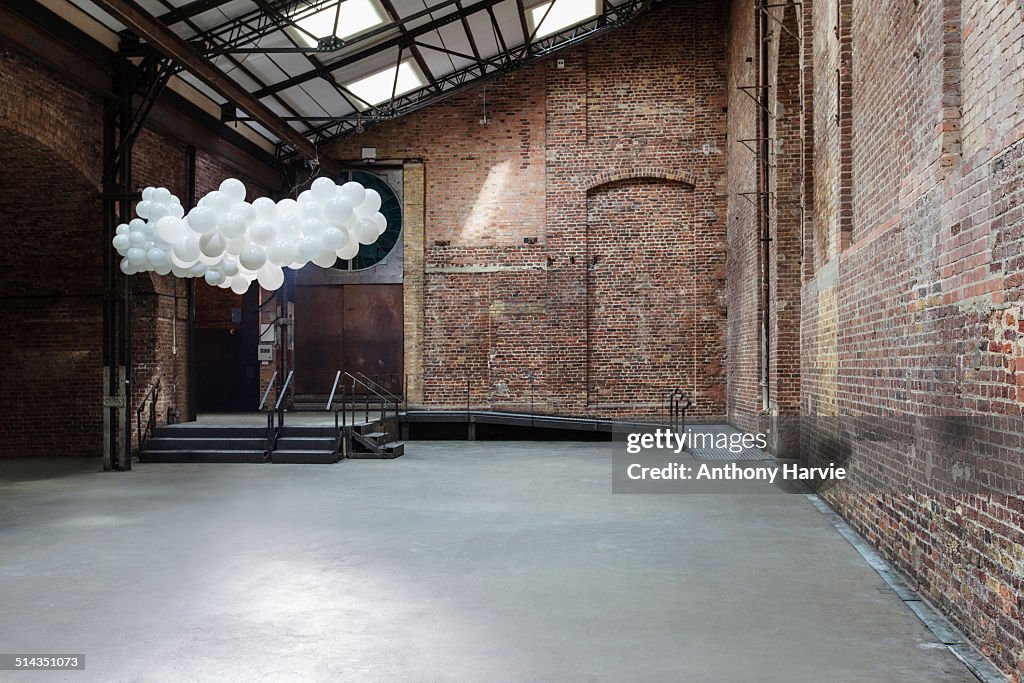 Empty warehouse with cloud made of balloons