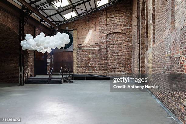 empty warehouse with cloud made of balloons - abandoned foto e immagini stock