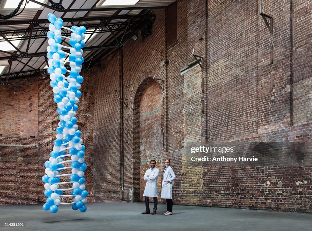 Scientists in warehouse with DNA made of balloons