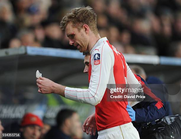 Per Mertesacker of Arsenal leaves the pitch with a head injury during the match between Hull City and Arsenal in the FA Cup 5th round at KC Stadium...