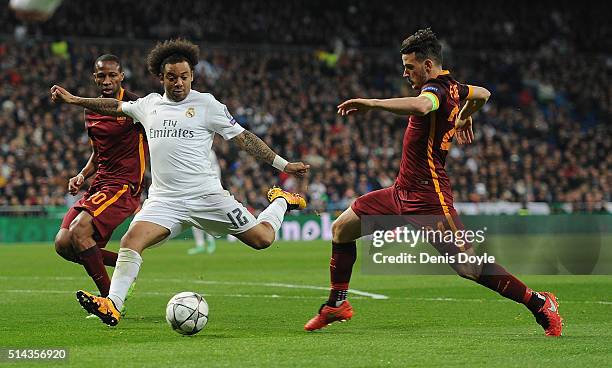 Marcelo of Real Madrid shoots past Alessandro Florenzi and Seydou Keita of AS Roma during the UEFA Champions League Round of 16 Second Leg match...