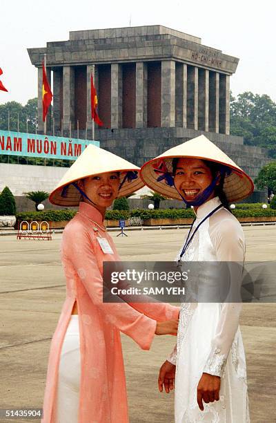 Two Vietnamese girls in traditional long suits pose in front of the Ho Chi Minh Mausoleum in Hanoi, 07 October 2004. Some 39 heads of the states will...