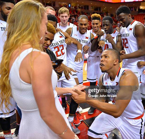 Toddrick Gotcher of the Texas Tech Red Raiders proposes to Kelly McQuaid as the Texas Tech Red Raiders look on after the game between the Texas Tech...