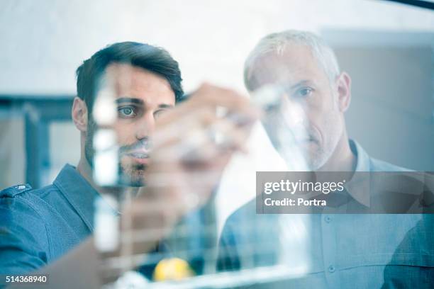 geschäftsleute, die planung für glaswand im büro - durchsichtig stock-fotos und bilder