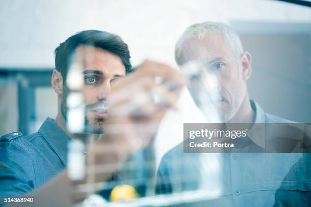 geschäftsleute, die planung für glaswand im büro - analysieren zusammenarbeit stock-fotos und bilder