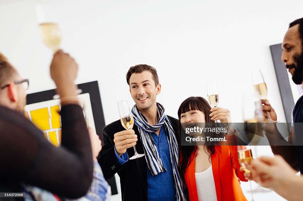 Happy group of people celebrating a gallery opening