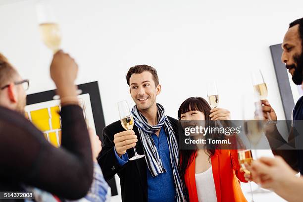 happy group of people celebrating a gallery opening - art gallery party stock pictures, royalty-free photos & images