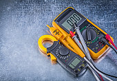 Digital clamp meter electric tester multimeter on metallic backg