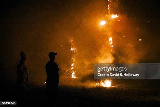 Supporters watch as crosses smolder during the closing ceremony of the Aryan Nations sponsored White Heritage Days Festival, which was held on...