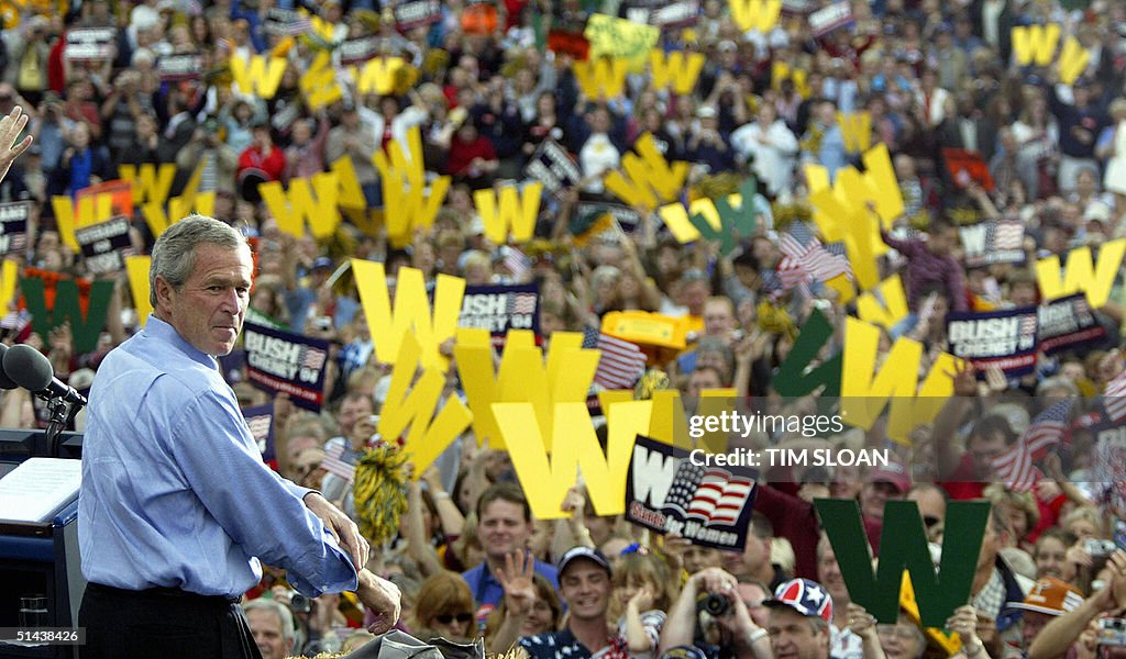 US President George W. Bush rolls up his