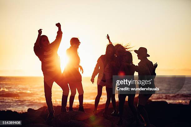 ヒップスターご友人とのダンス日没の光の中で、ビーチ - light party ストックフォトと画像