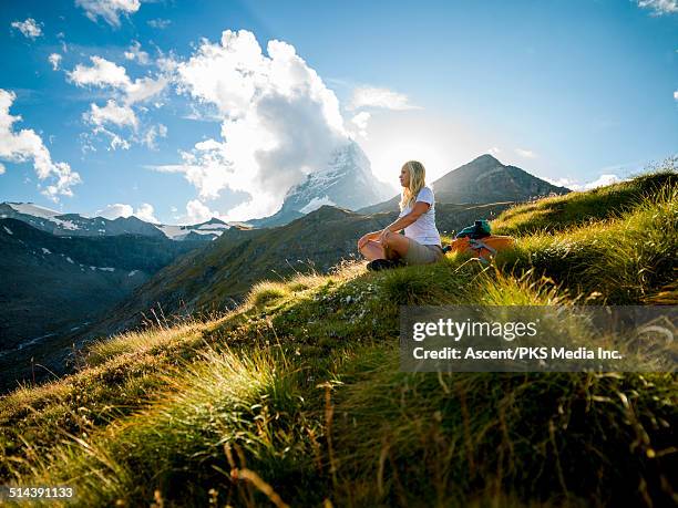 woman relaxes in mountain meadow below matterhorn - kanton wallis 個照片及圖片檔