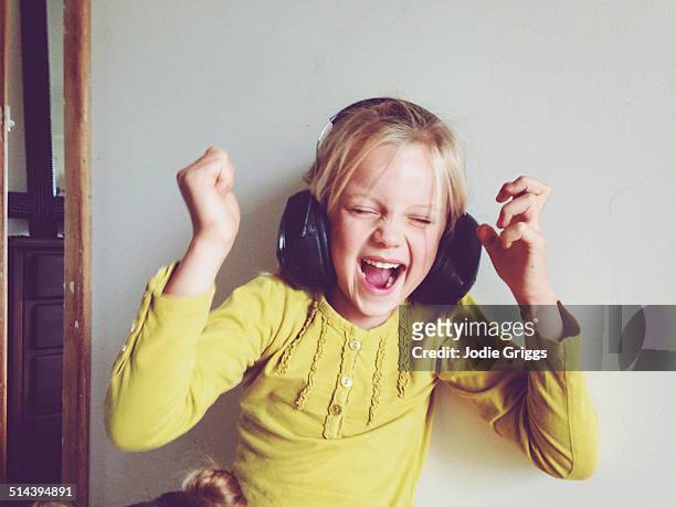 Child wearing safety earmuffs screaming loudly