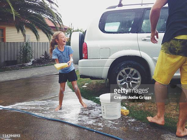 father and daughter having fun washing the car - familie auto stock pictures, royalty-free photos & images