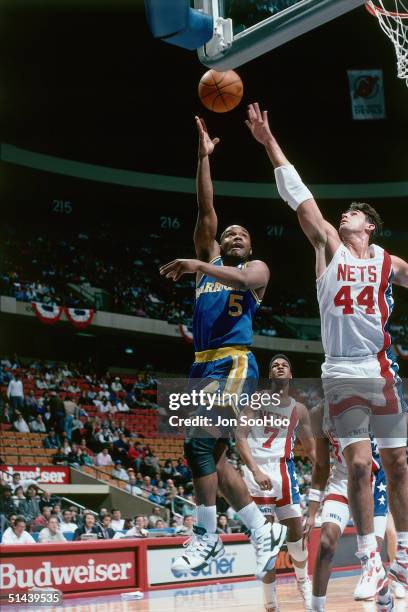 Tim Hardaway of the Golden State Warriors shoots a hook shot against the New Jersey Nets during an NBA game at the Brendan Byrne Arena in 1989 in...