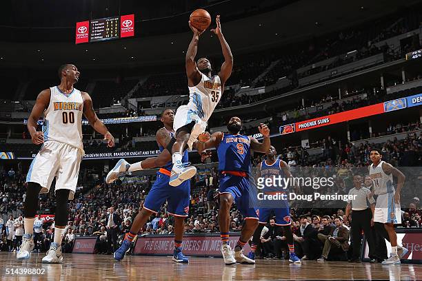 Kenneth Faried of the Denver Nuggets goes up for a shot and is fouled by Kyle O'Quinn of the New York Knicks at Pepsi Center on March 8, 2016 in...