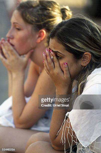 Israeli girls cry as they talk on the phone after they crossed the border into the Israeli town of Eilat from the Egyptian resort of Taba, on October...