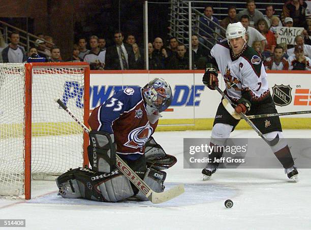 Keith Tkachuk of the Phoenix Coyotes looks for a rebound as goaltender Patrick Roy of the Colorado Avalanche makes a save during their game at the...