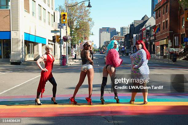 drag queens posing on rainbow pavement on city street, toronto, ontario, canada - drag stock pictures, royalty-free photos & images