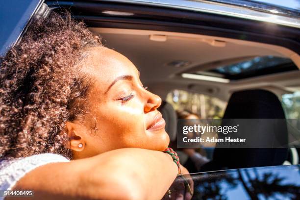 black woman leaning out car window - young black girlfriends fotografías e imágenes de stock