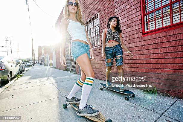 women riding skateboards on city street - a la moda stock pictures, royalty-free photos & images