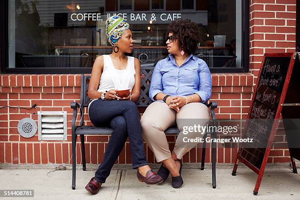 women talking outside coffee shop on city street - new york personas fotografías e imágenes de stock