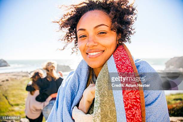 woman wrapped in blanket on rural hillside - us girls on the beach stock-fotos und bilder