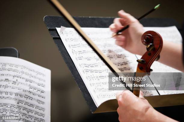 close up of student writing on sheet music - soliste photos et images de collection