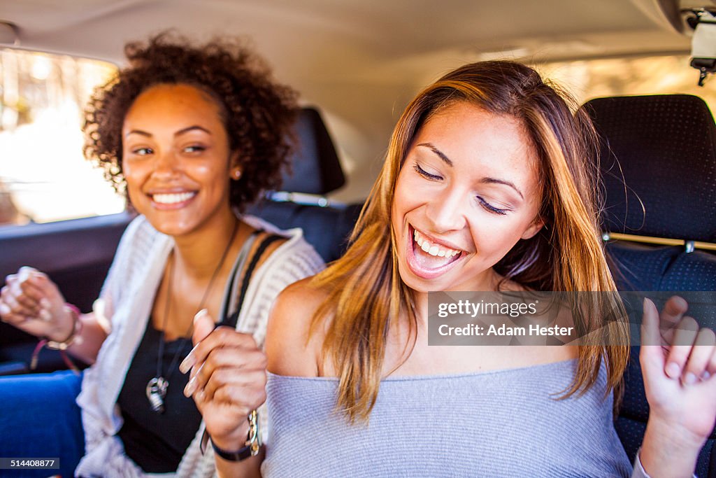 Women dancing together in car